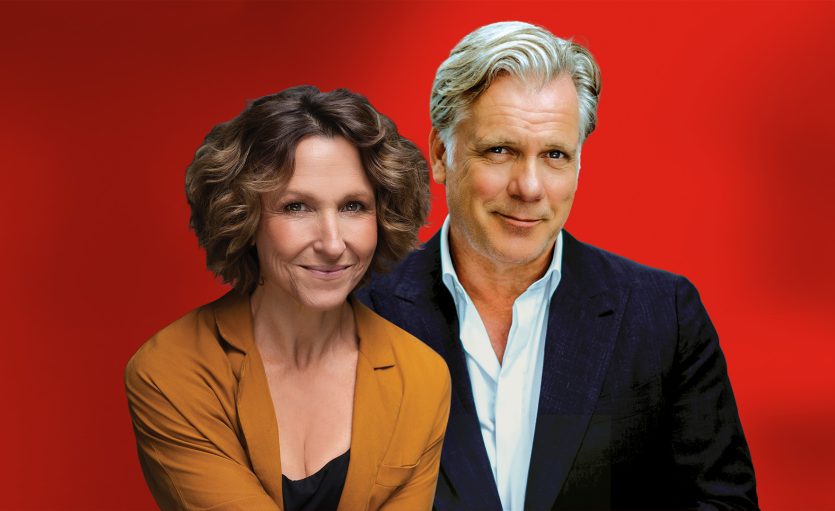 Blazey Best in orange shirt next to Erik Thomson in navy suit jacket and white shirt, both smiling